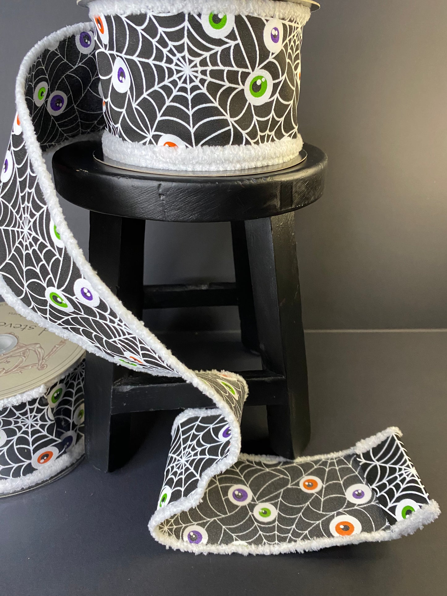 Halloween Ribbon with Spiderwebs and Eyeballs in a black with a fuzzy edge.  It's a 2.5"x10yds poplin ribbon.
