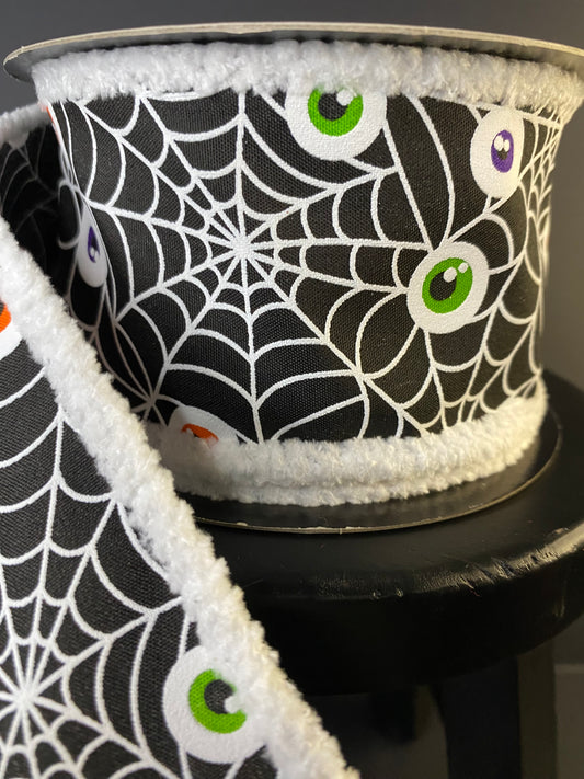 Halloween Ribbon with Spiderwebs and Eyeballs in a black with a fuzzy edge.  It's a 2.5"x10yds poplin ribbon.